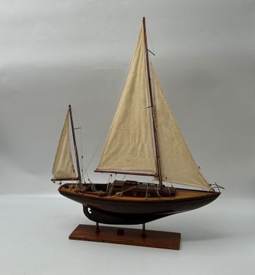 une petite maquette de voilier posée sur un socle en bois
