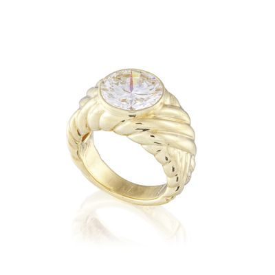 gros plan d'une bague en or avec un diamant au centre