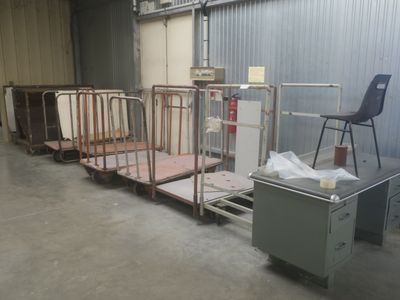 a room with a lot of beds and a chair in it