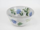 a white bowl with blue and green flowers on it