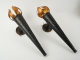 une paire de torches noires et dorées posées sur une surface blanche