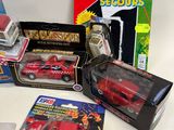 several toy cars are sitting on a table next to boxes of toys