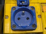 a blue and yellow electrical outlet on a yellow box