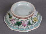 a small white bowl with flowers on it on a table