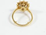 a close up of a gold ring with a diamond center