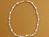 a close up of a white pearl necklace on a brown background