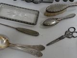 a lot of silver spoons and other silverware on a table