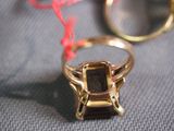 a gold ring with a brown stone in it