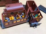 a toy train car with two doors open on the ground