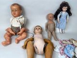 three dolls sitting next to each other on a white surface