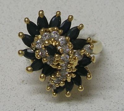 une photo d'une bague en diamant en noir et blanc posée sur une surface blanche