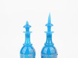 pair of blue glass vases with silver designs on the sides