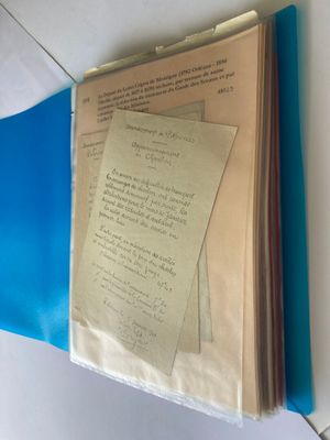 a blue folder with papers on it on a table