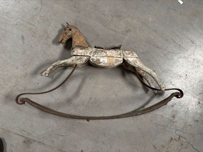un cheval à bascule en bois posé sur une surface métallique
