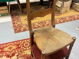 une chaise en bois avec une assise rouge dans une pièce