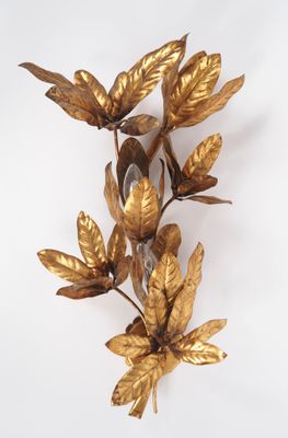 une applique murale en feuille d'or sur fond blanc