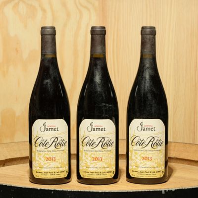 three bottles of wine sitting on top of a barrel