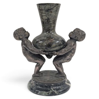 une statue représentant deux personnes tenant un vase posé sur une table