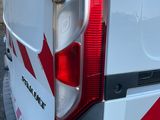 l'arrière d'une camionnette blanche ornée d'une bande rouge