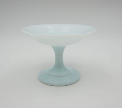 une image représentant un bol sur pied en verre bleu sur fond blanc