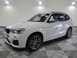 Le SUV BMW blanc est garé dans une grande pièce