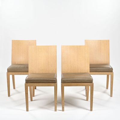 three wooden chairs with leather upholstered seats against a white backdrop