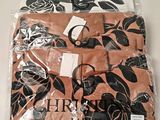 trois chemises dans un sac en plastique orné de fleurs noires et blanches