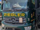 un camion vert garé devant un immeuble