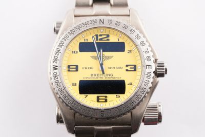 une montre en argent avec un cadran jaune sur fond blanc