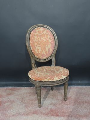 an old chair with a red and gold upholstered seat