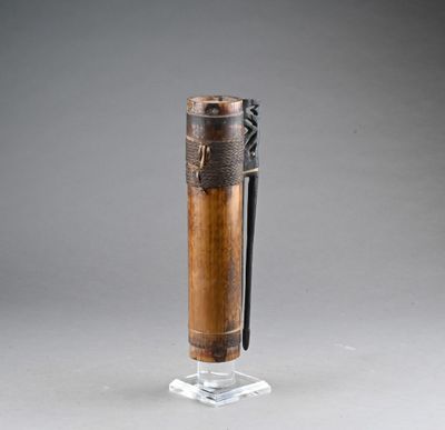 une vieille pipe en bois avec un manche noir, posée sur un socle transparent