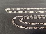 a silver chain that is laying on a black surface