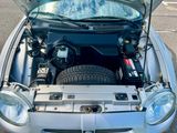 une voiture argentée avec le capot ouvert et le capot relevé