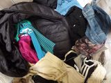 a pile of clothes that is sitting on a bed