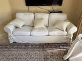 a white couch with pillows on it in a living room