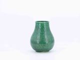 a green vase that is sitting on a white surface