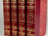 three red books sitting on top of each other on a white surface