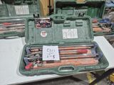 de nombreux outils divers rangés dans une mallette verte posée sur une table