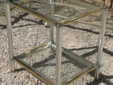 pair of chrome and glass side tables in the style of maison
