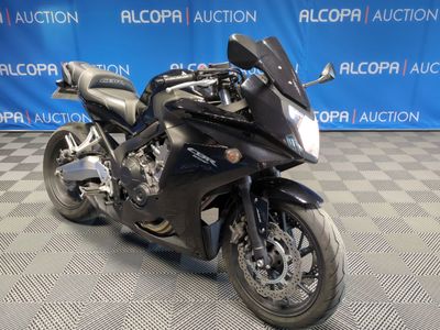 une moto noire garée sur un sol à damier
