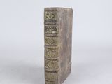 an old book that is sitting on a white surface