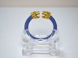bracelet composé de perles bleues et dorées montées sur un support transparent
