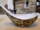 a bowl sitting on a table with a stone wall in the background