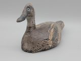 un petit canard posé sur une surface blanche