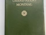un vieux livre vert posé sur une table, à côté d'une tasse de café