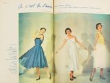 an open book with a picture of a woman in a blue dress and a woman in a white dress