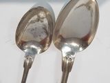 two spoons that are sitting on a table