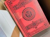 a red book sitting in a box on the floor