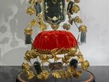 a gold and red chair with a red cushion on it