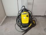 a yellow and black pressurer on the floor next to a black and yellow hose